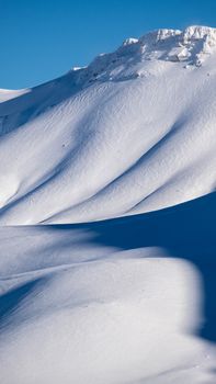 Serene snowy mountain landscape in Isparta, Türkiye, showcasing pristine white slopes and clear blue skies.