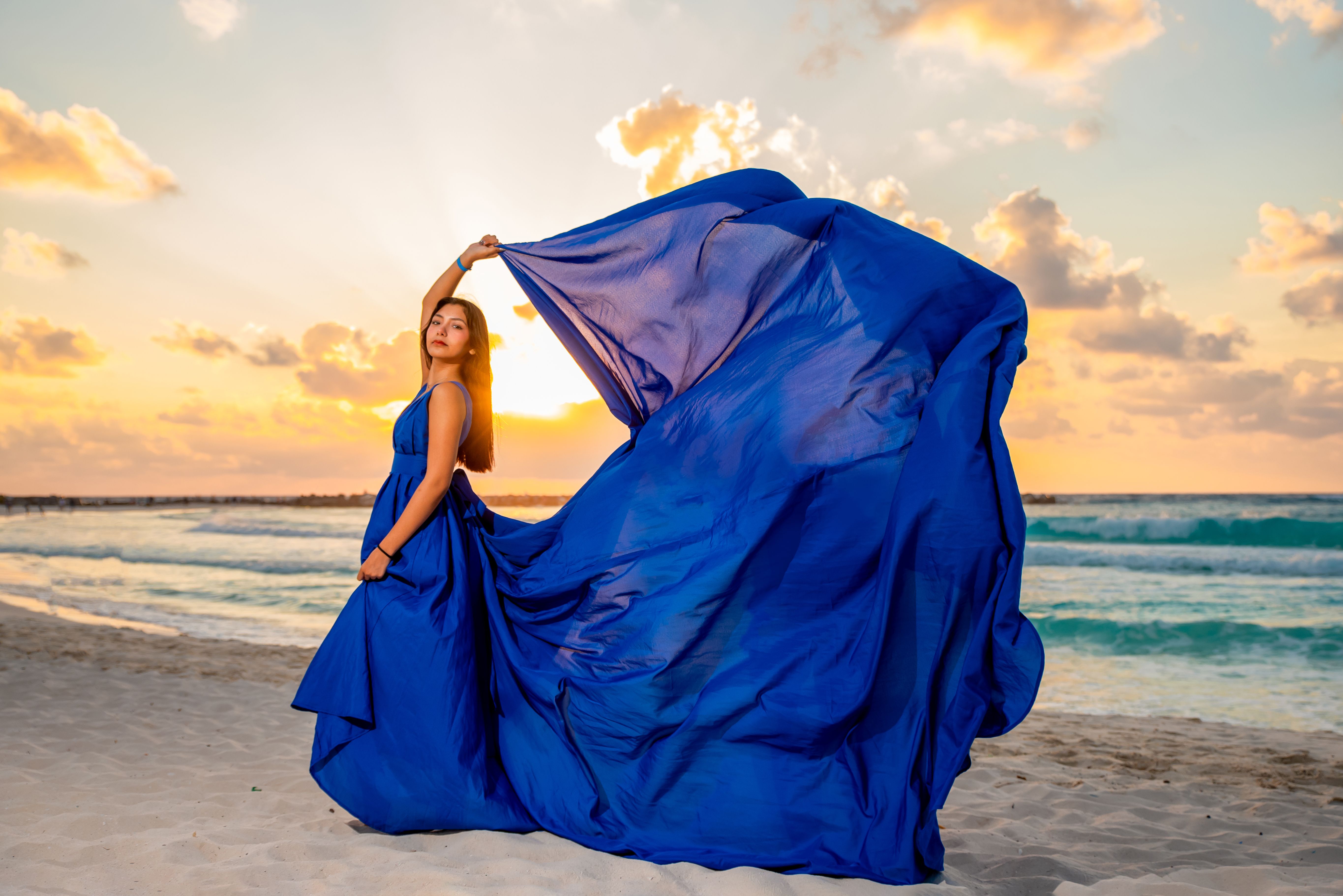Elegant Woman in Flowing Blue Dress on Beach at Sunset · Free Stock Photo