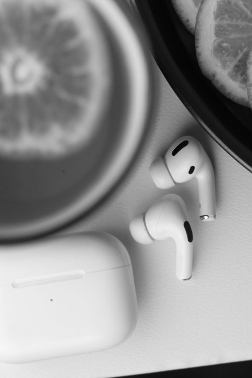 Free Black and white image of AirPods with citrus slices creating a minimalist and modern vibe. Stock Photo