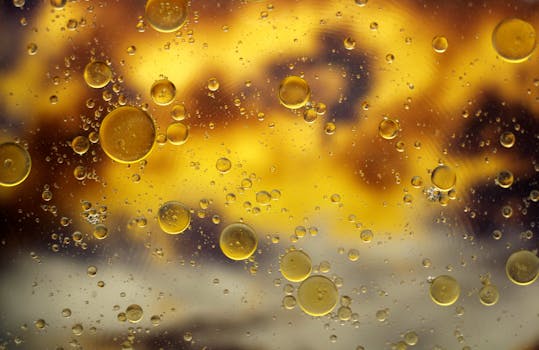 Artistic close-up of oil bubbles suspended in water with vibrant golden hues.