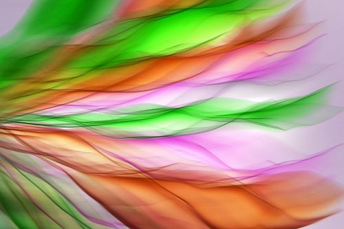 Free Vivid abstract image of motion blur with green, orange, and pink hues resembling flowing feathers. Stock Photo