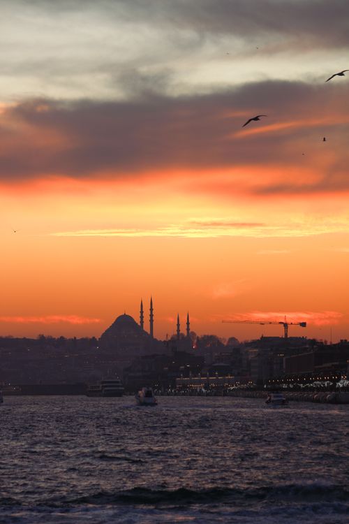 Free Silhouette of Istanbul skyline at sunset with Suleymaniye Mosque in view over the Bosphorus. Stock Photo