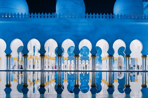 Free Captivating view of Sheikh Zayed Mosque arches reflected in water at night. Stock Photo