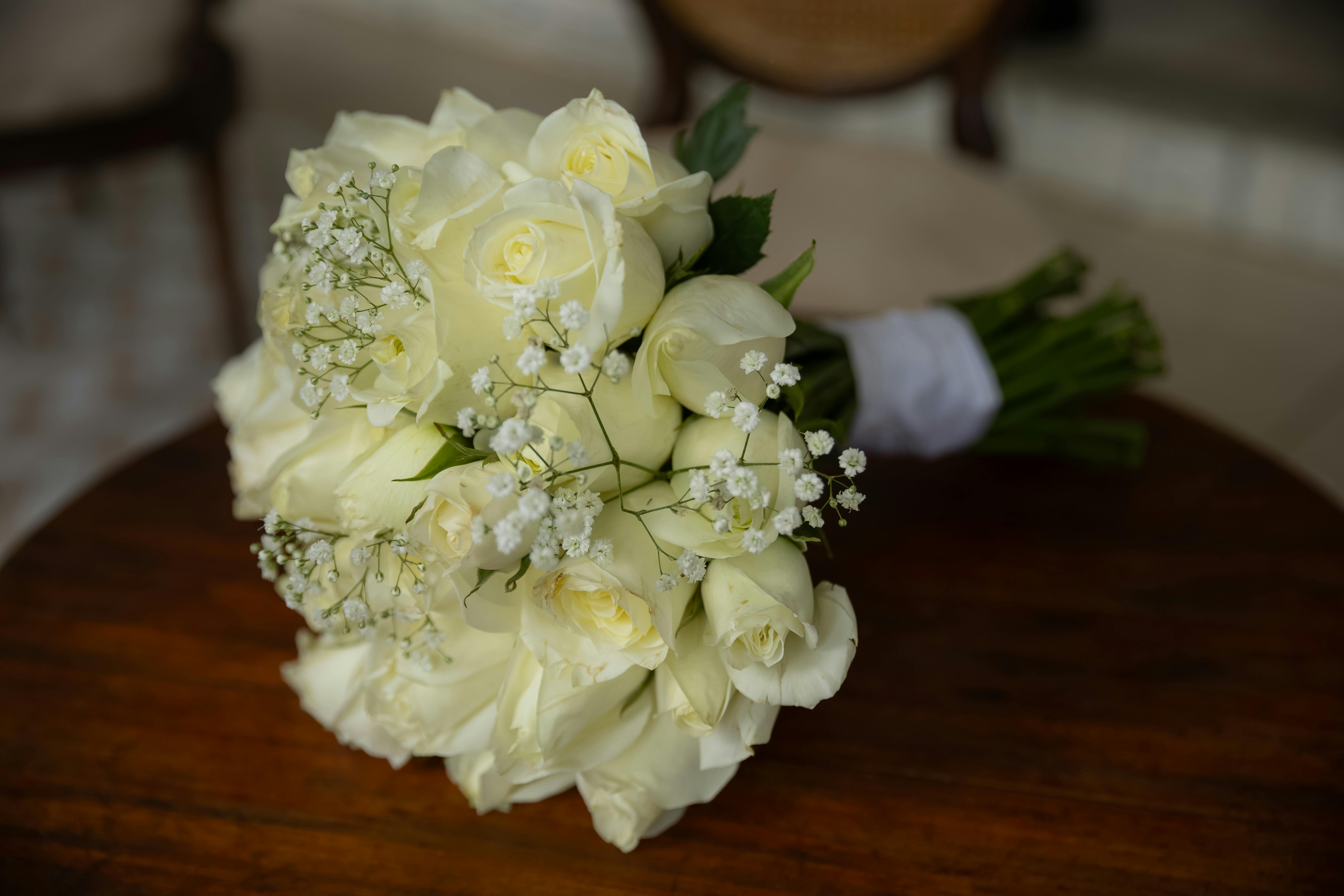 [ColoSach]-a-beautiful-bouquet-of-white-roses-elegantly-arranged-on-a-wooden-table.