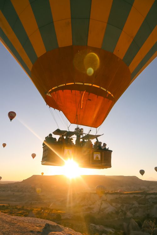 Free Hot air balloons soaring at sunrise over Cappadocia's unique landscape. Stock Photo