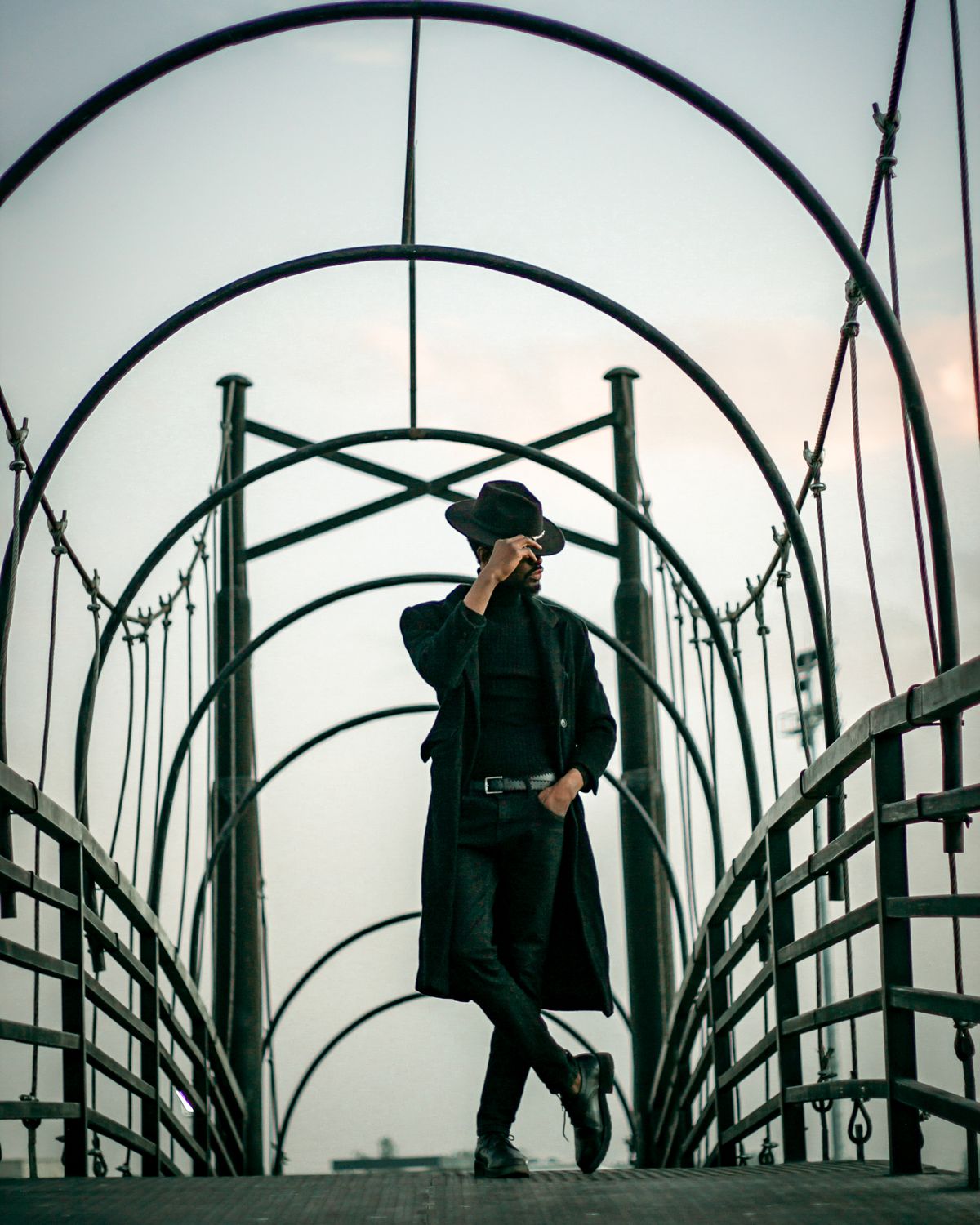 Stylish Man Posing on Modern Arch Bridge · Free Stock Photo