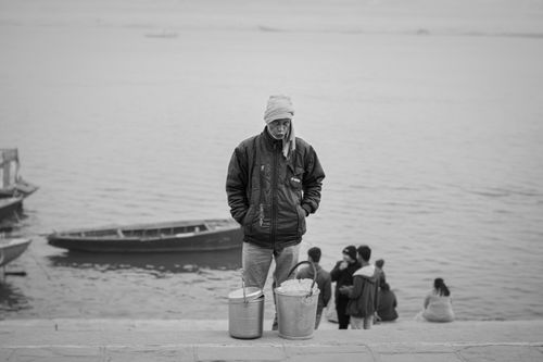 Free Black and white photo of an elderly vendor by the Ganges River in Varanasi, India. Stock Photo