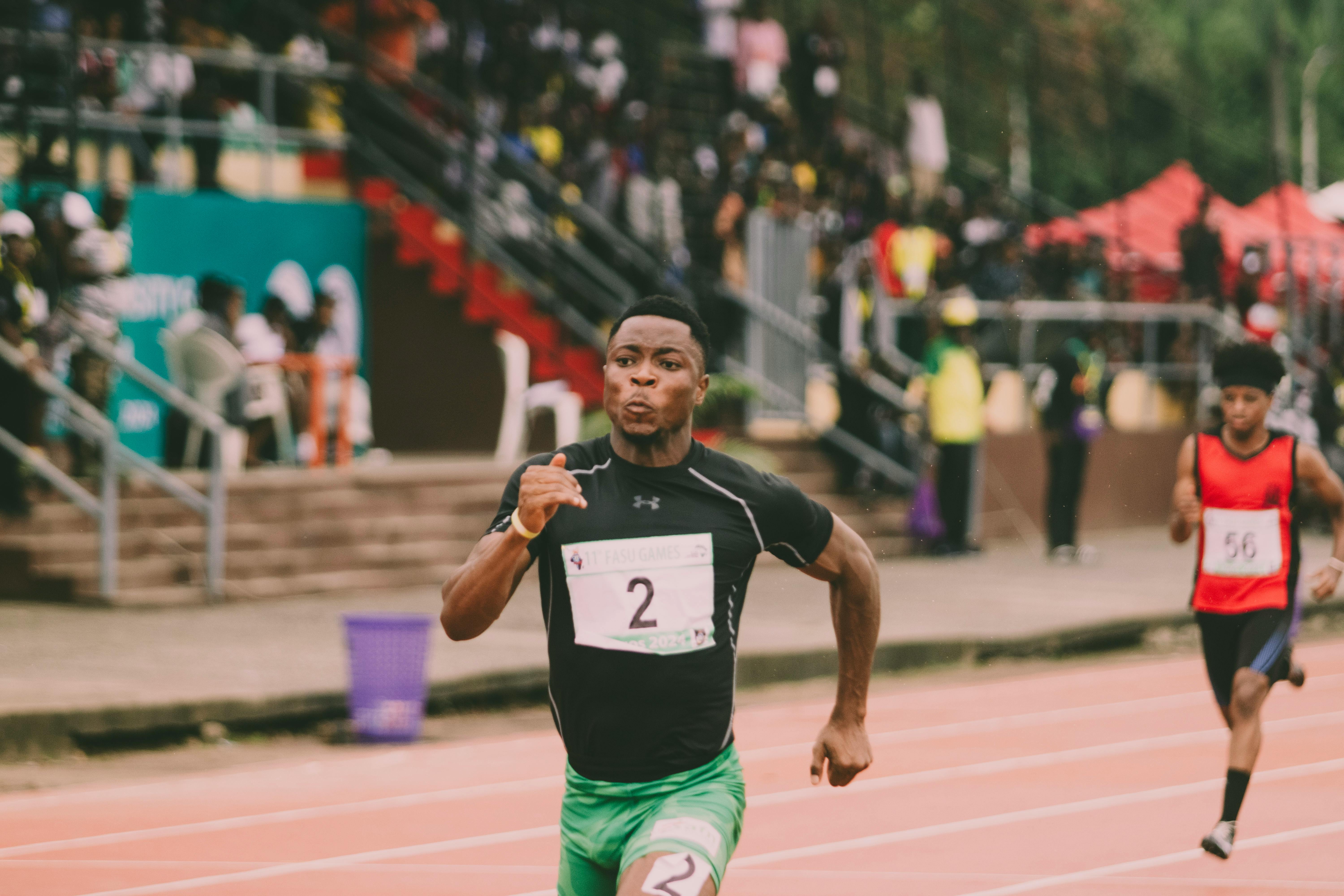 Athlete in green shorts sprinting on track, racing towards victory