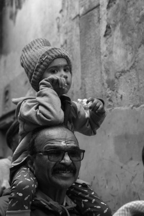 Free Black and white portrait of a child on a man's shoulders in Varanasi. Stock Photo