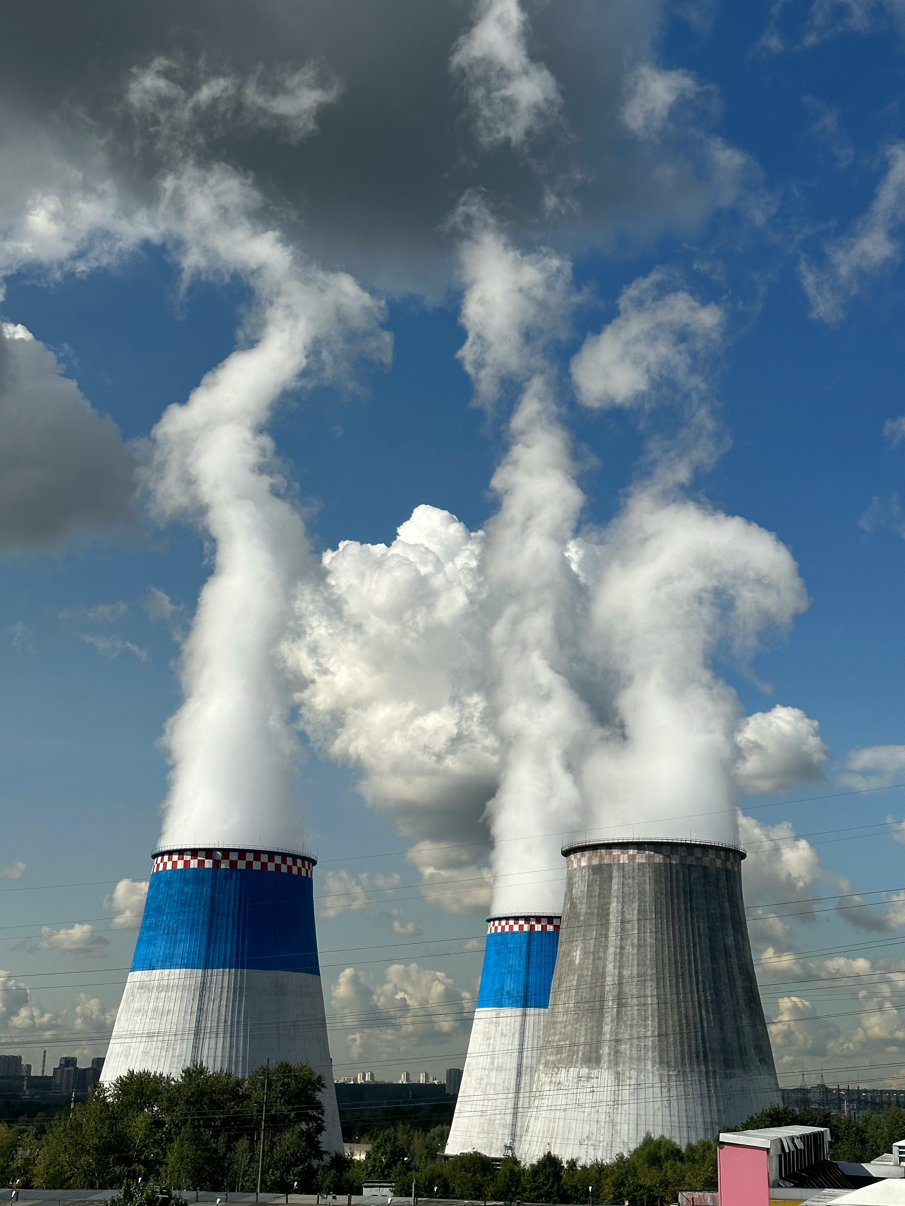 Gratuit Trois tours de refroidissement industrielles libérant de la vapeur sous un ciel bleu éclatant. Photos