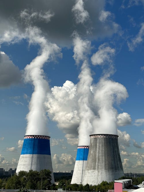 Gratuit Trois tours de refroidissement industrielles libérant de la vapeur sous un ciel bleu éclatant. Photos