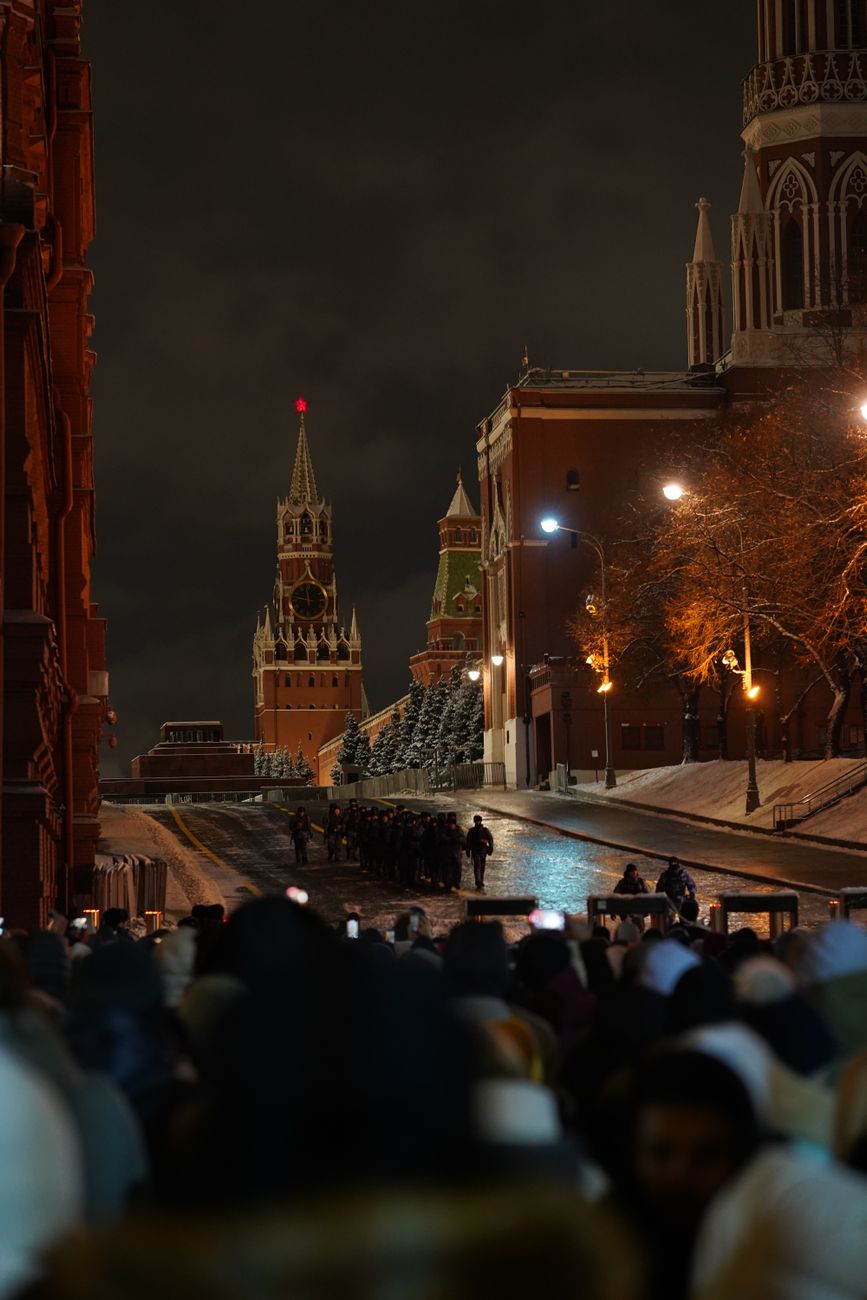 Crowds gather near Spasskaya Tower on Red Square during an evening in Moscow.
