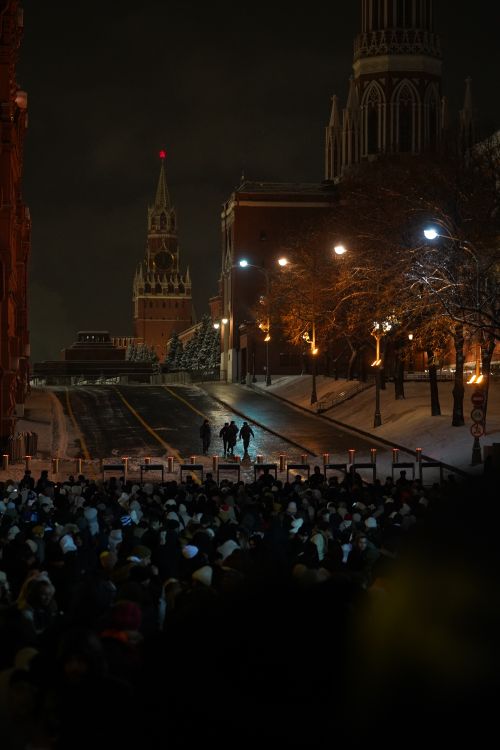 Free Large crowd gathered near Kremlin at night during winter, showcasing city lights. Stock Photo