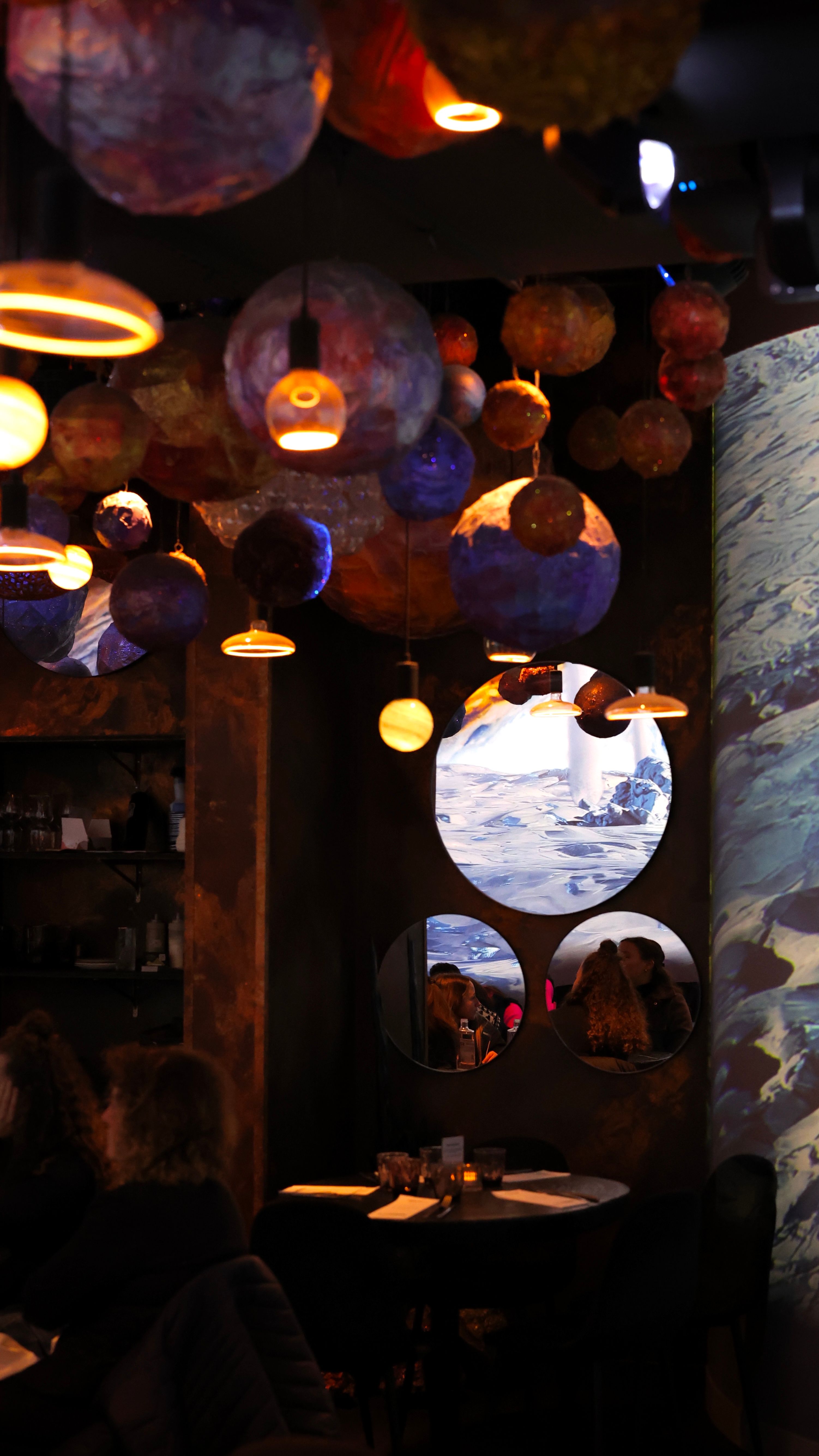 Warm, cozy ambiance inside a Paris restaurant with captivating ceiling lights and reflections.