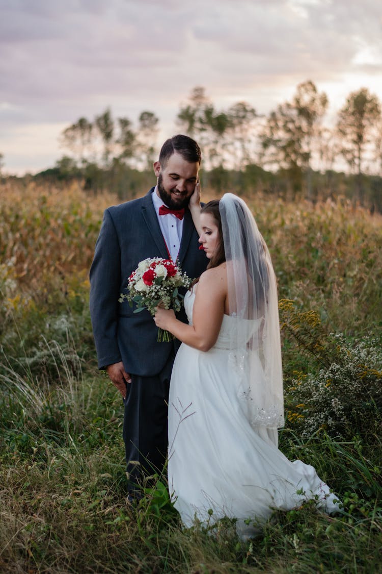 Groom And Bride Standing On Grass