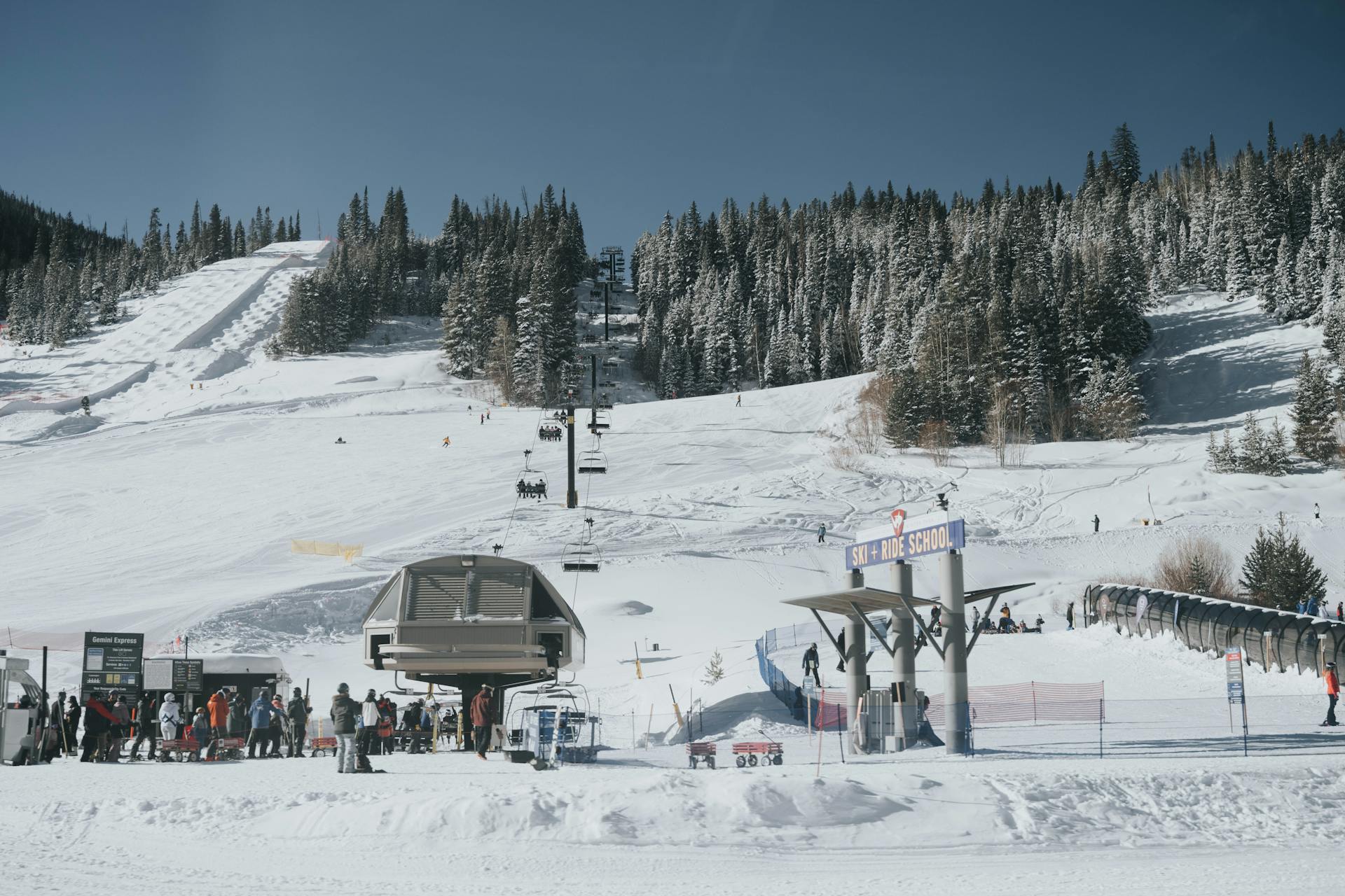 A bustling ski resort in Colorado with snow-covered slopes and people enjoying winter sports.