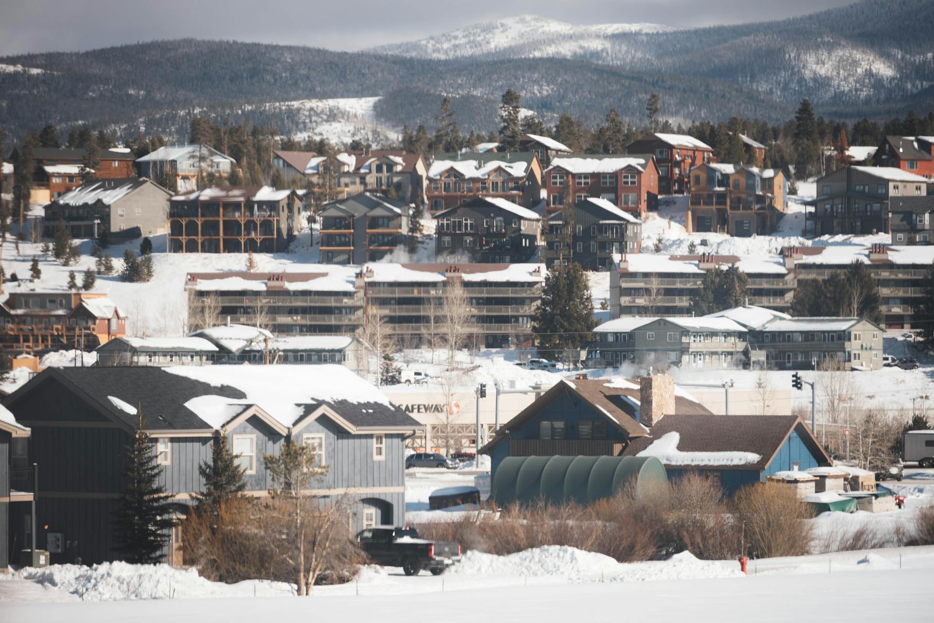 Winter view of a snow-covered suburban town in Colorado with residential homes and mountain backdrop.