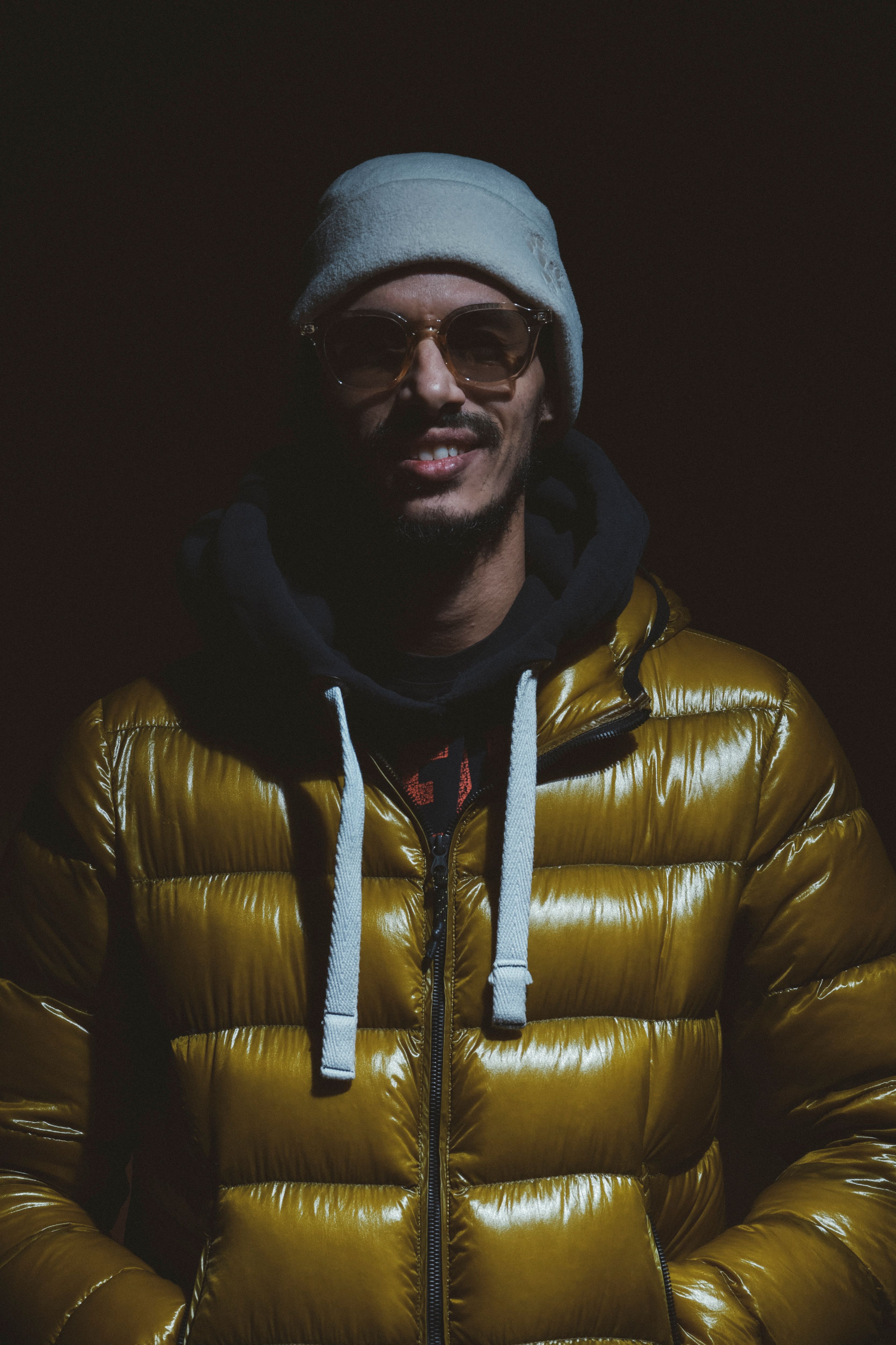 Stylish portrait of a young man in a yellow puffer jacket and beanie, exuding a cool vibe.