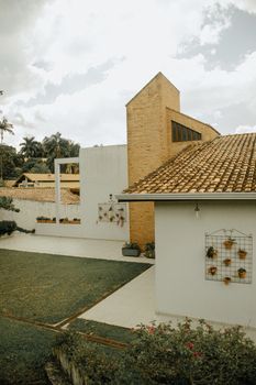 Stylish brick house with tiled roof and outdoor garden area under cloudy sky.