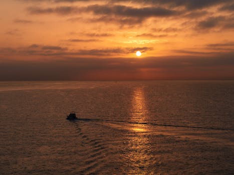 Captivating sunrise over the sea near Malaga with a boat creating a tranquil scene.