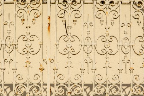 Free Close-up of a vintage rusted iron fence with intricate details and shadows. Stock Photo