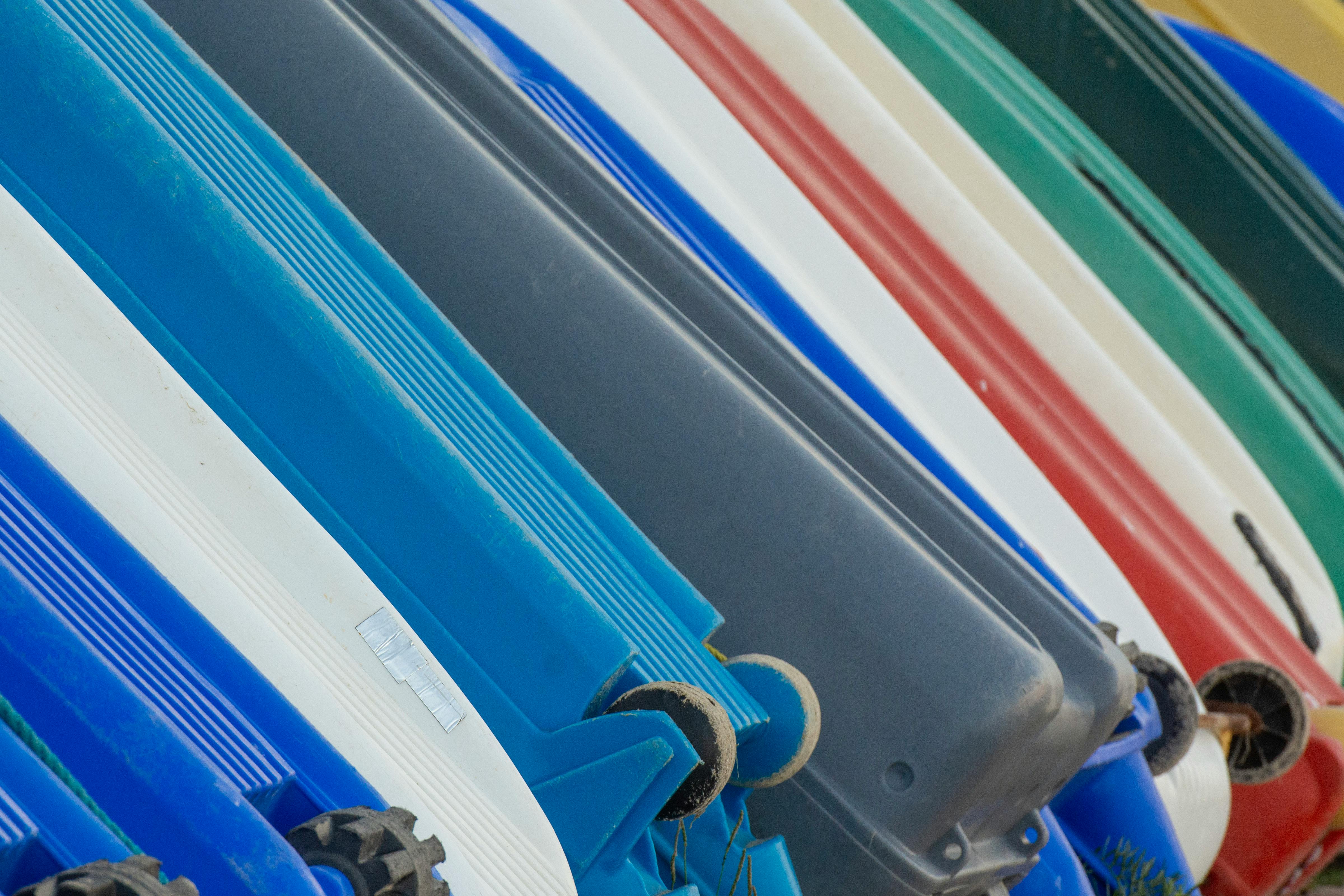 Top view of colorful kayaks stored in rows outdoors.