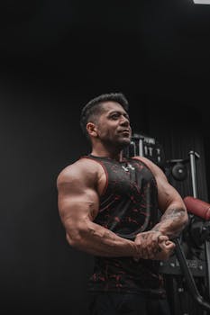 Strong athlete showing physique in a gym environment with equipment.