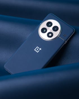 A stylish smartphone with three cameras on a textured blue leather surface.