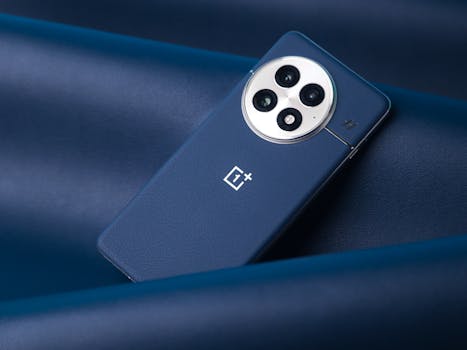Close-up of a modern smartphone with a triple camera setup on a blue leather background.