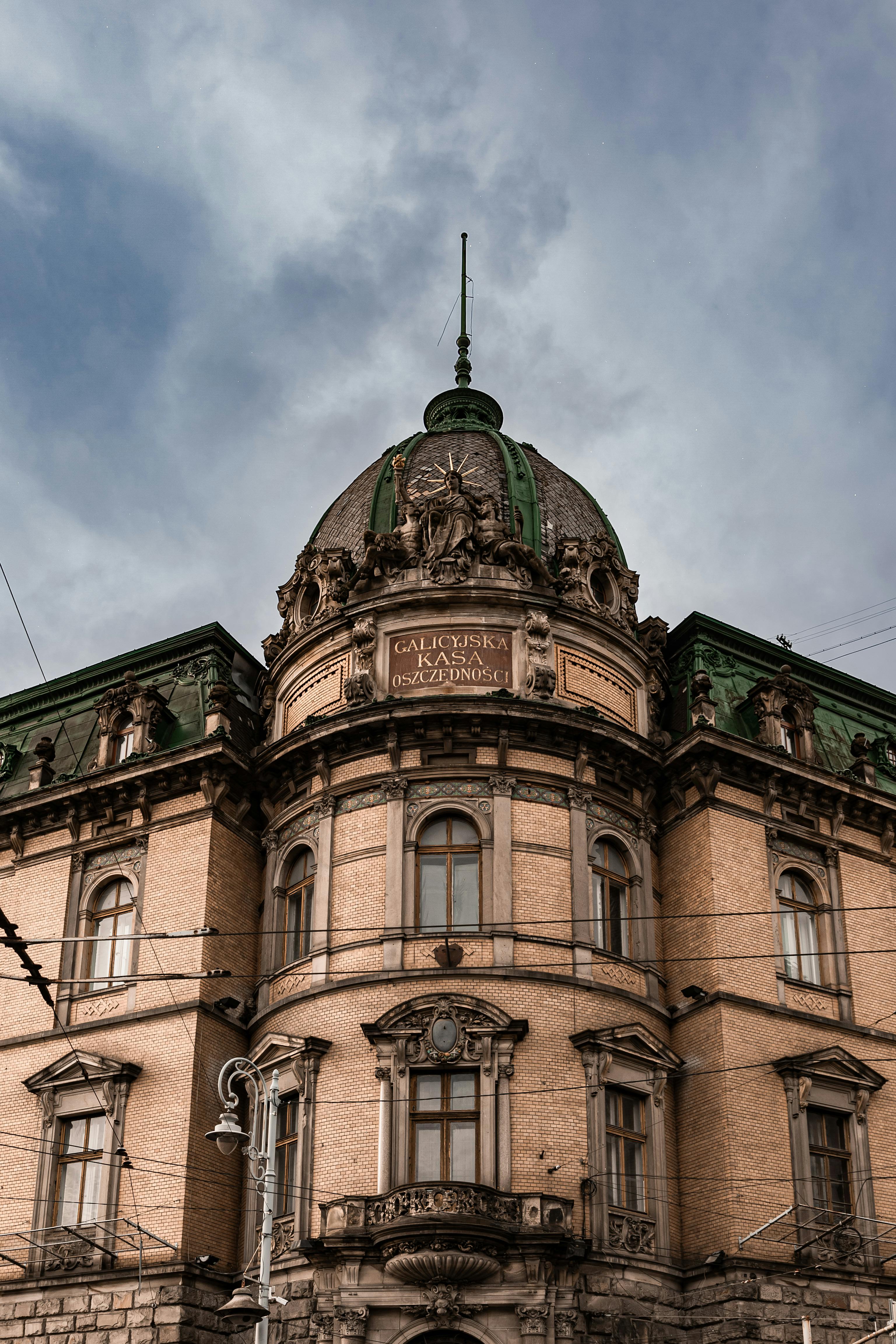 Close-up of a historic building in Lviv, featuring intricate designs and a cloudy sky.
