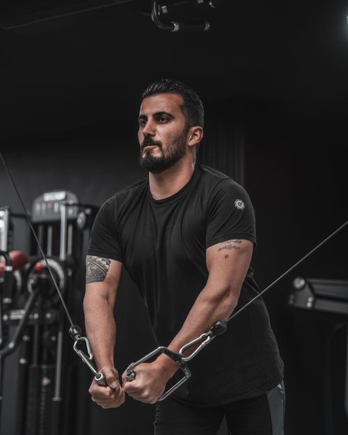 Free Fit man working out on cable machine at gym, focusing on strength training. Stock Photo