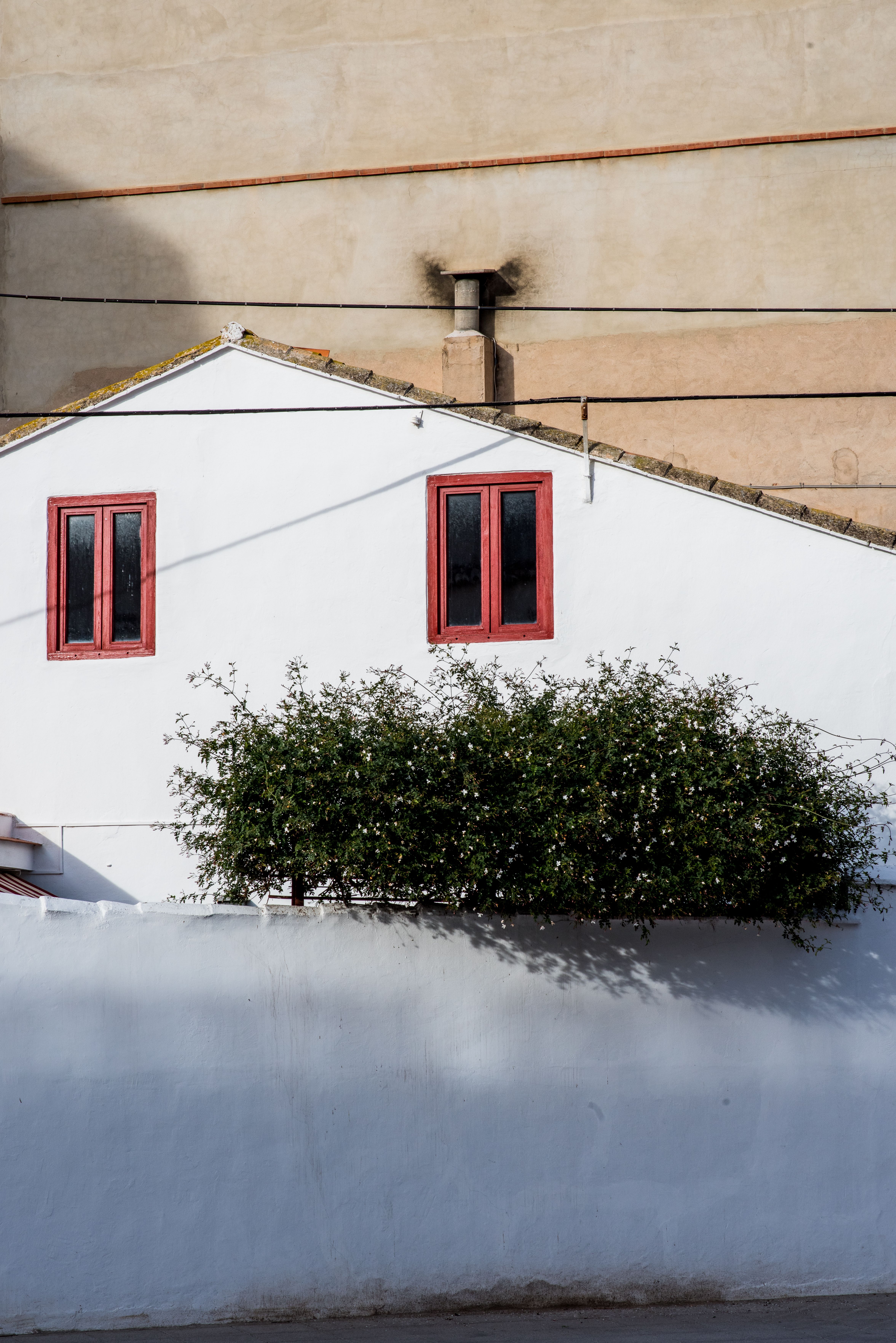 Fachada De La Casa Blanca Con Ventanas Rojas Y Vegetación · Foto de ...