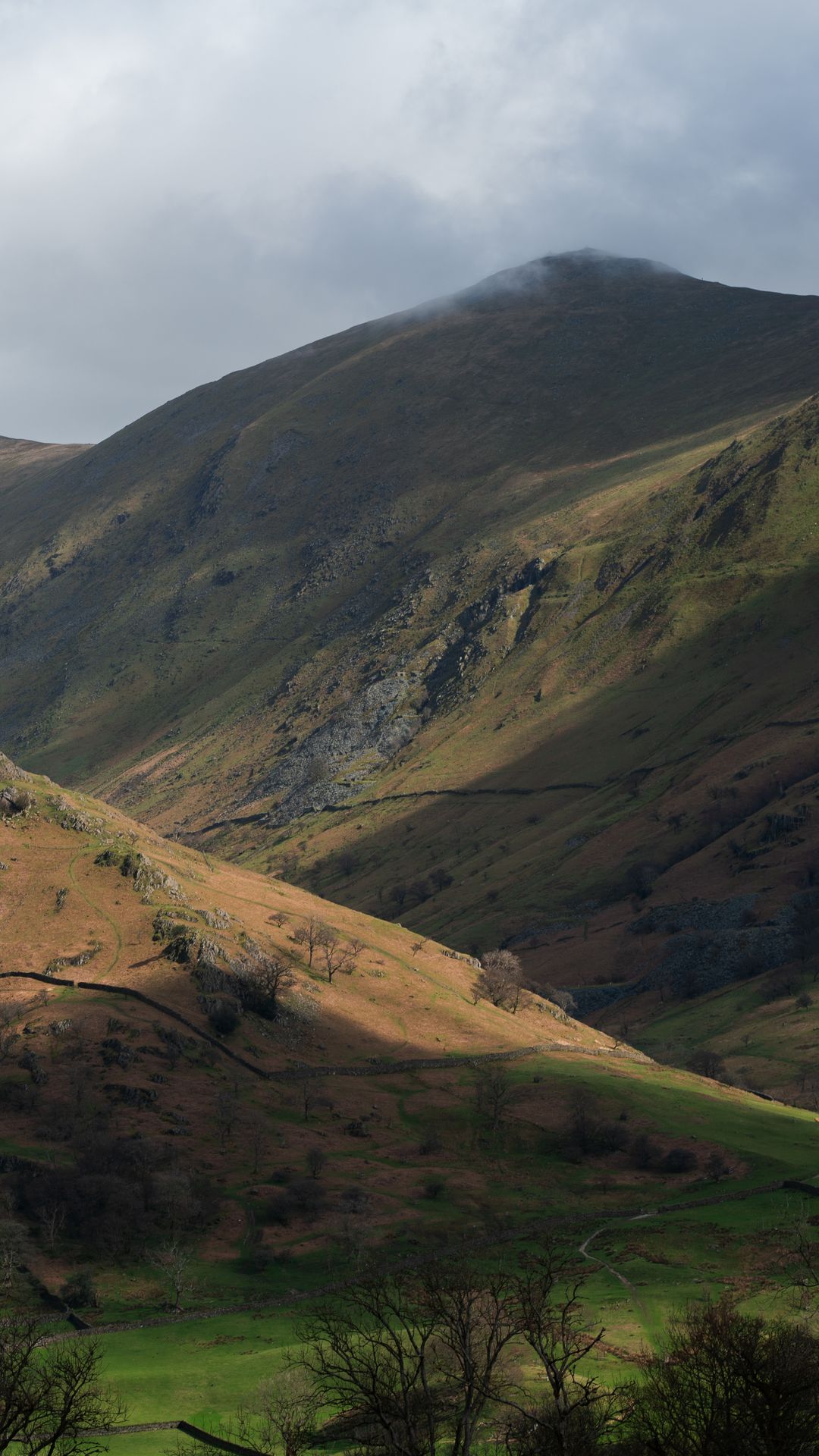 Breathtaking rolling hills and valleys in England's Lake District with soft mist and atmospheric light — calm, timeless British landscape