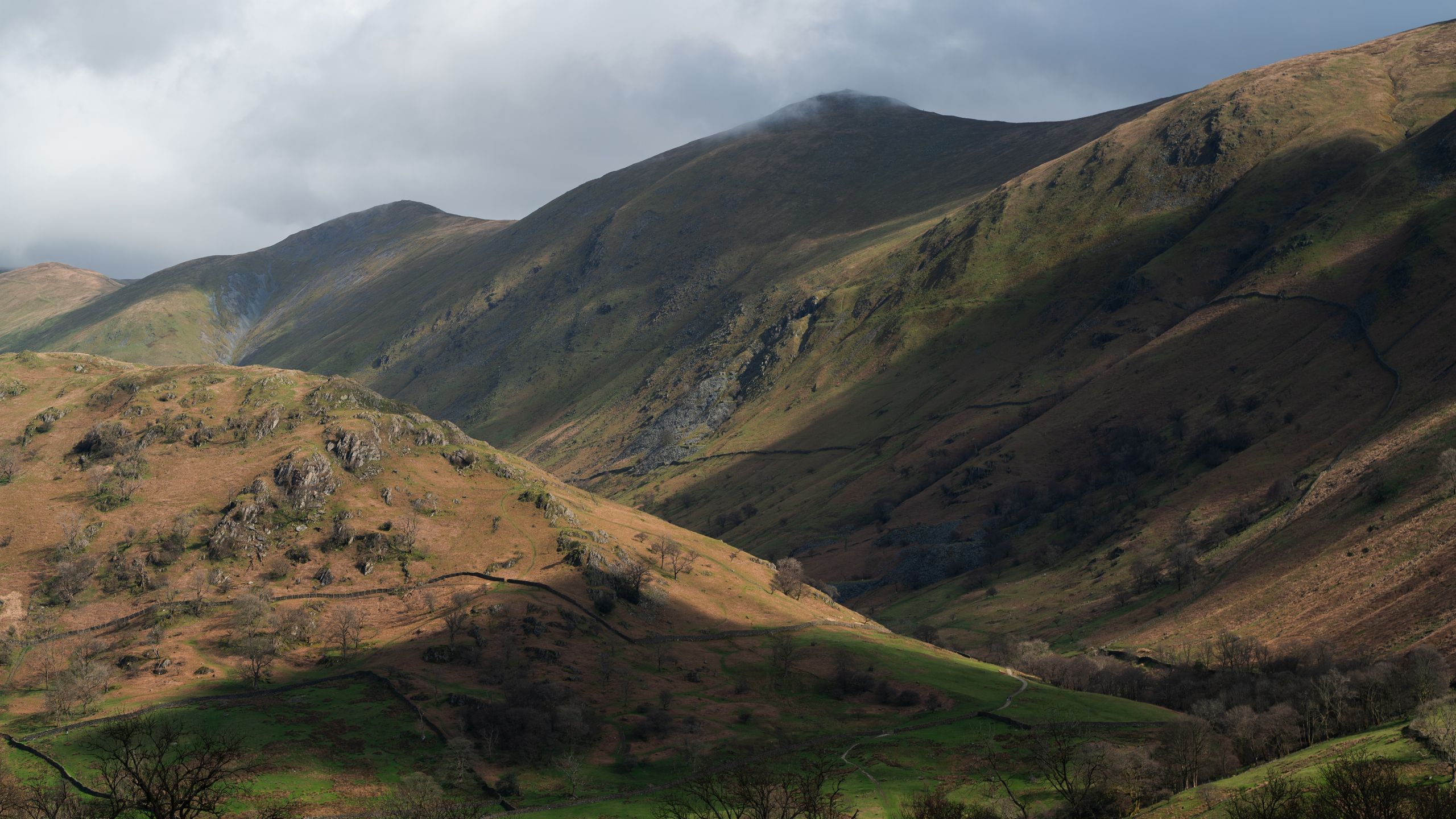 Breathtaking rolling hills and valleys in England's Lake District with soft mist and atmospheric light — calm, timeless British landscape