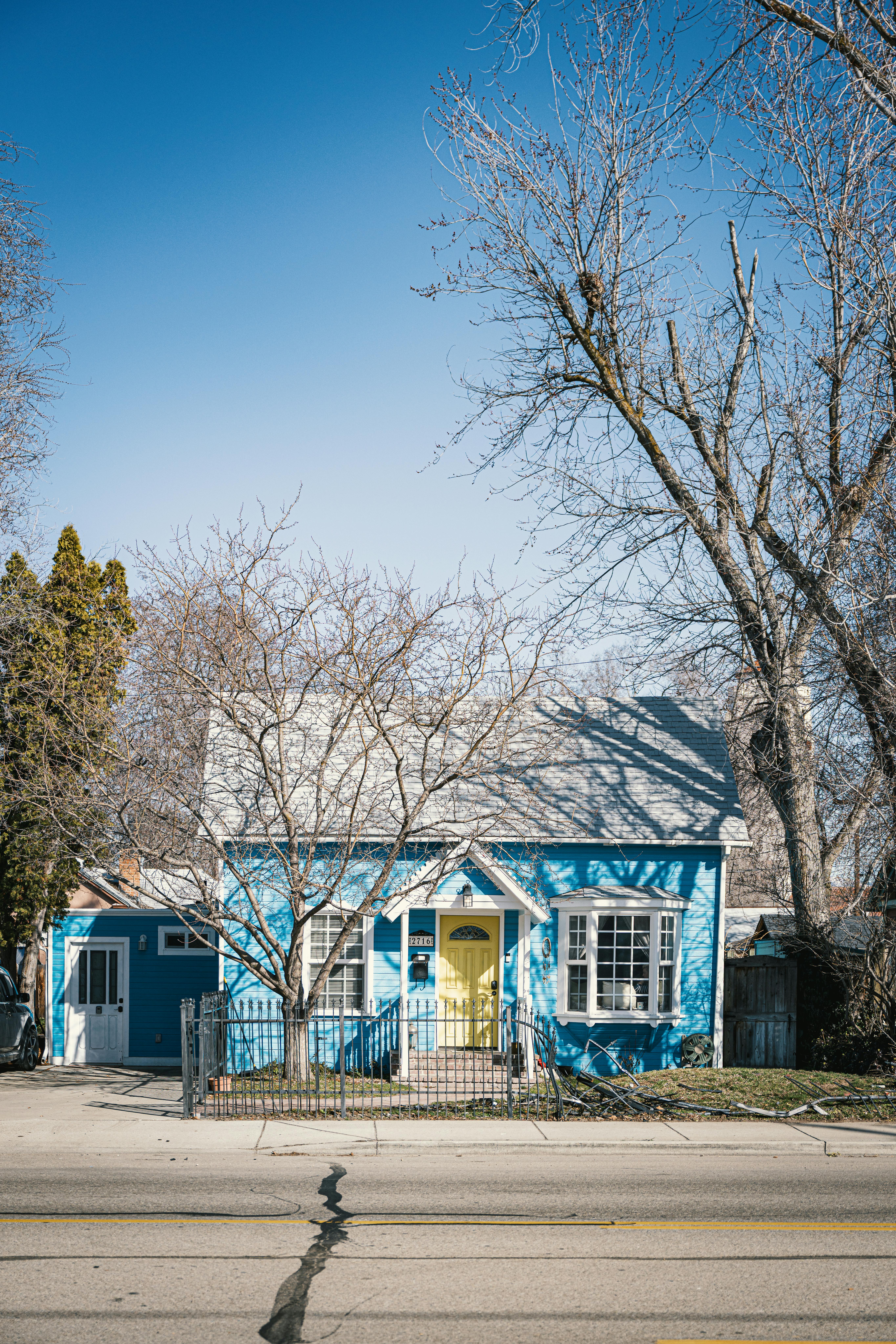 A quaint blue house in Boise, Idaho, captured during winter with clear blue skies.