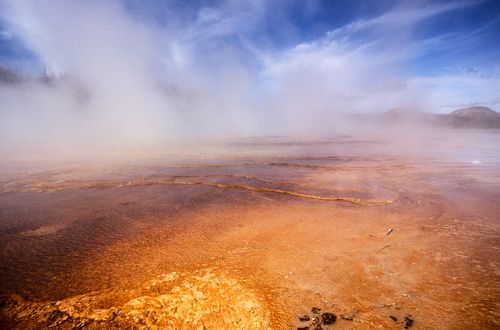 Free Vibrant colors and misty geyser at Yellowstone National Park's iconic hot spring. Stock Photo