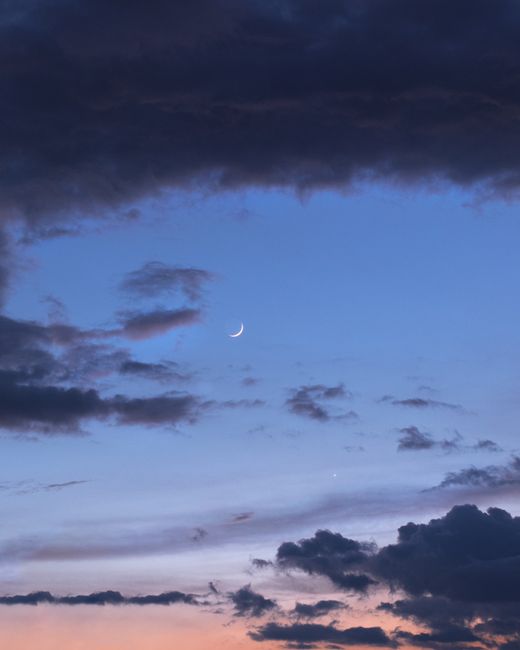 Calm twilight with crescent moon and clouds in North Macedonia's sky.