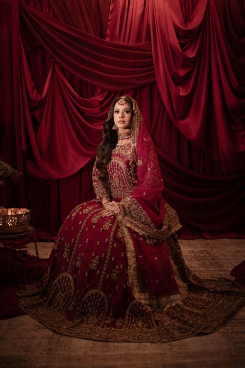 Free Stunning portrait of a bride in ornate red attire against a luxurious backdrop. Stock Photo