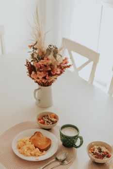 A warm and inviting breakfast scene with eggs, toast, and floral decor.
