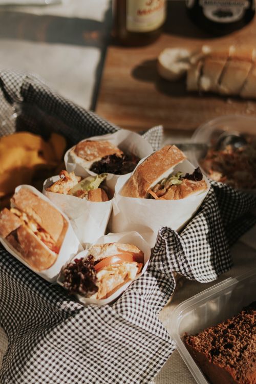 Free Gourmet sandwiches wrapped in paper on a picnic table, perfect for outdoor dining enthusiasts. Stock Photo