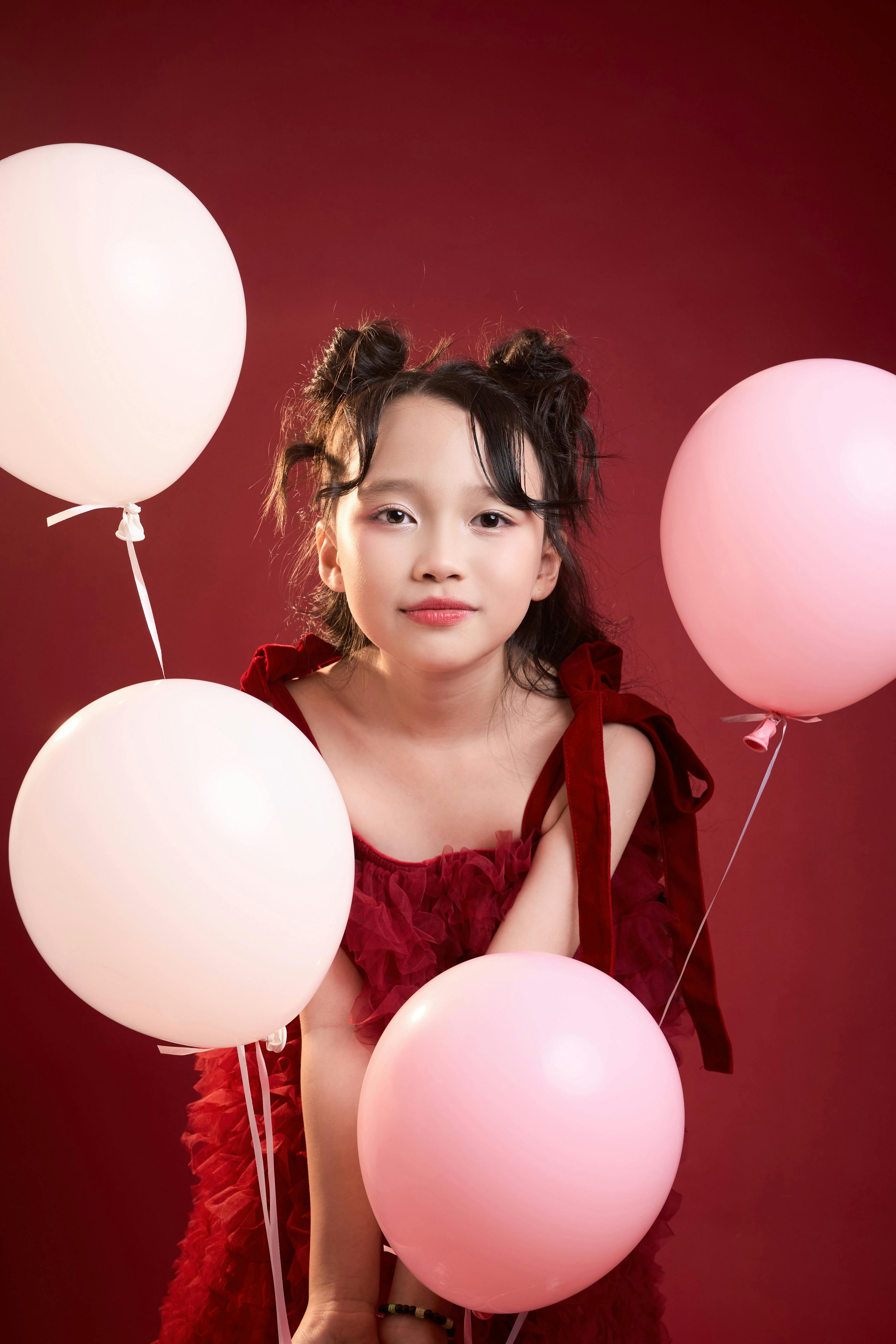 Gratis Adorable jovencita posando con globos en un vibrante entorno de estudio. Foto de stock