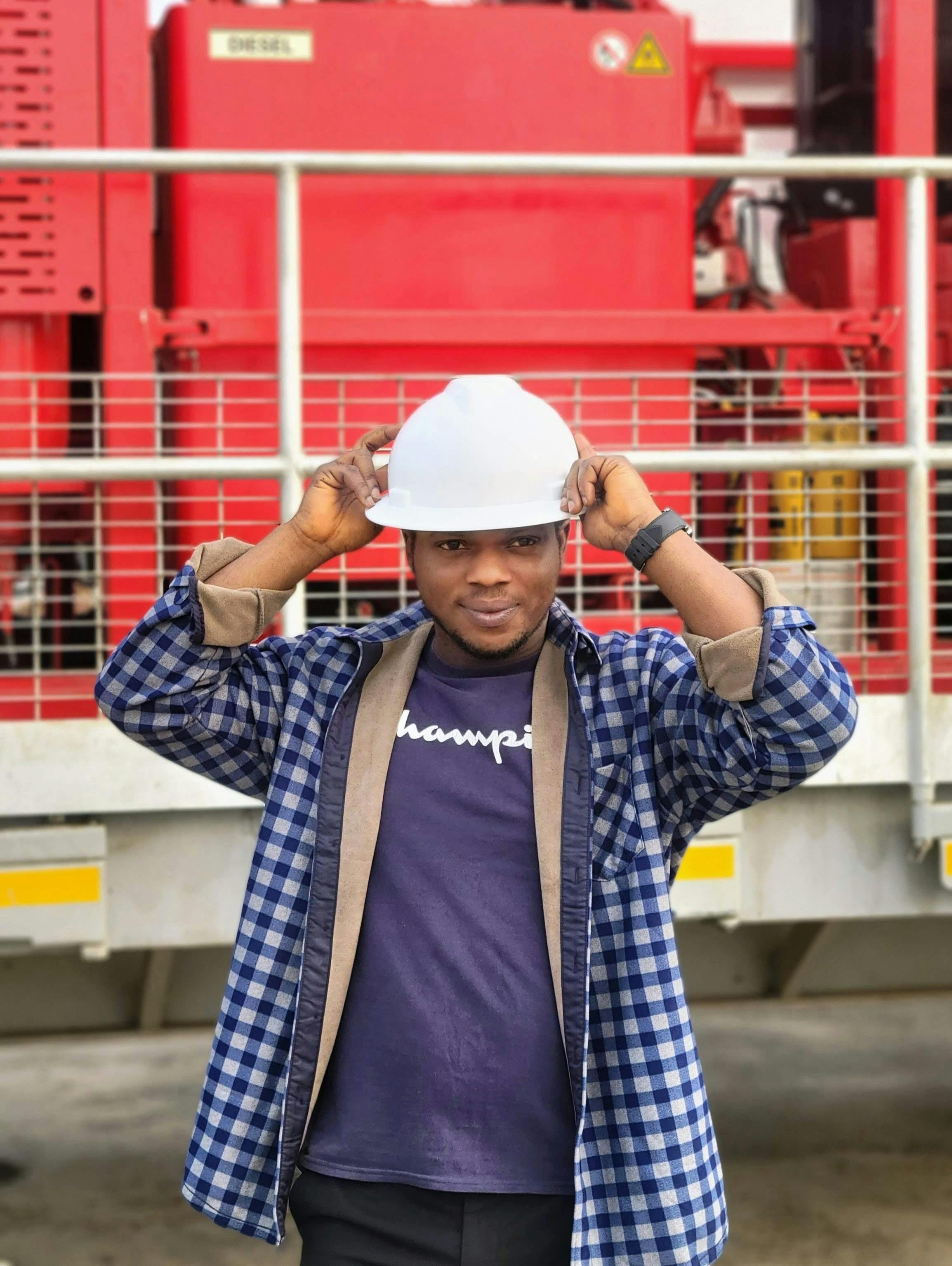 Man wearing a safety helmet at construction site with heavy machinery.