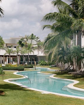 Elegant tropical resort featuring a winding pool, palm trees, and relaxing atmosphere.