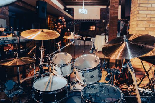 Close-up view of a drum kit set up in a cozy indoor music studio setting.