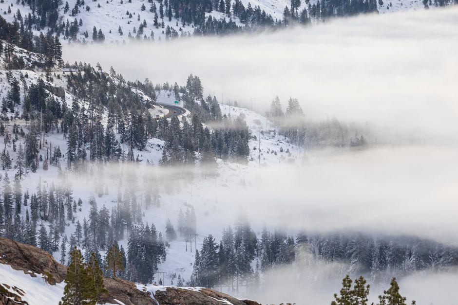 Foggy winter morning over snowy mountains of Donner Pass, a stunning natural scene in California.
