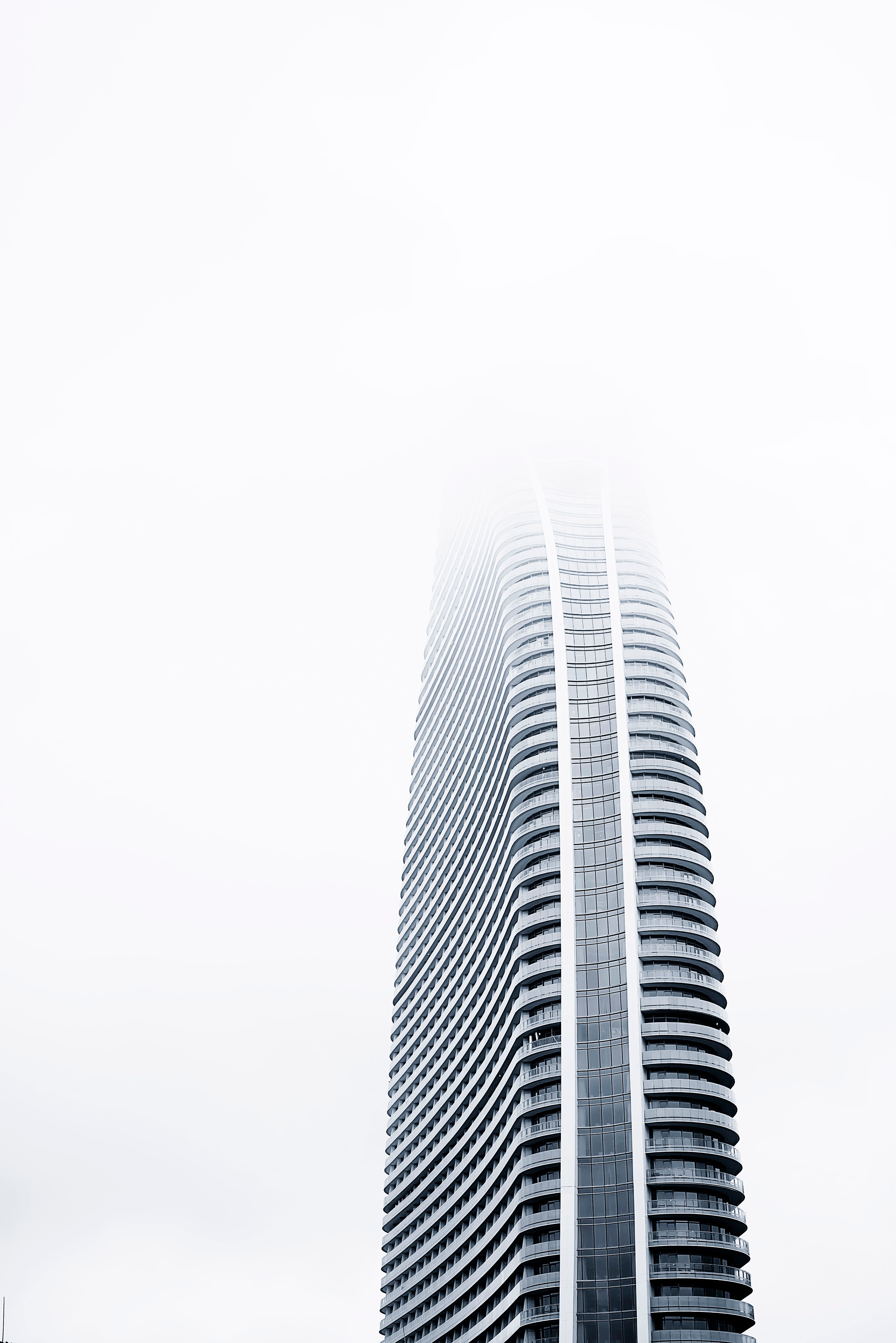 modern high rise tower in foggy skyline