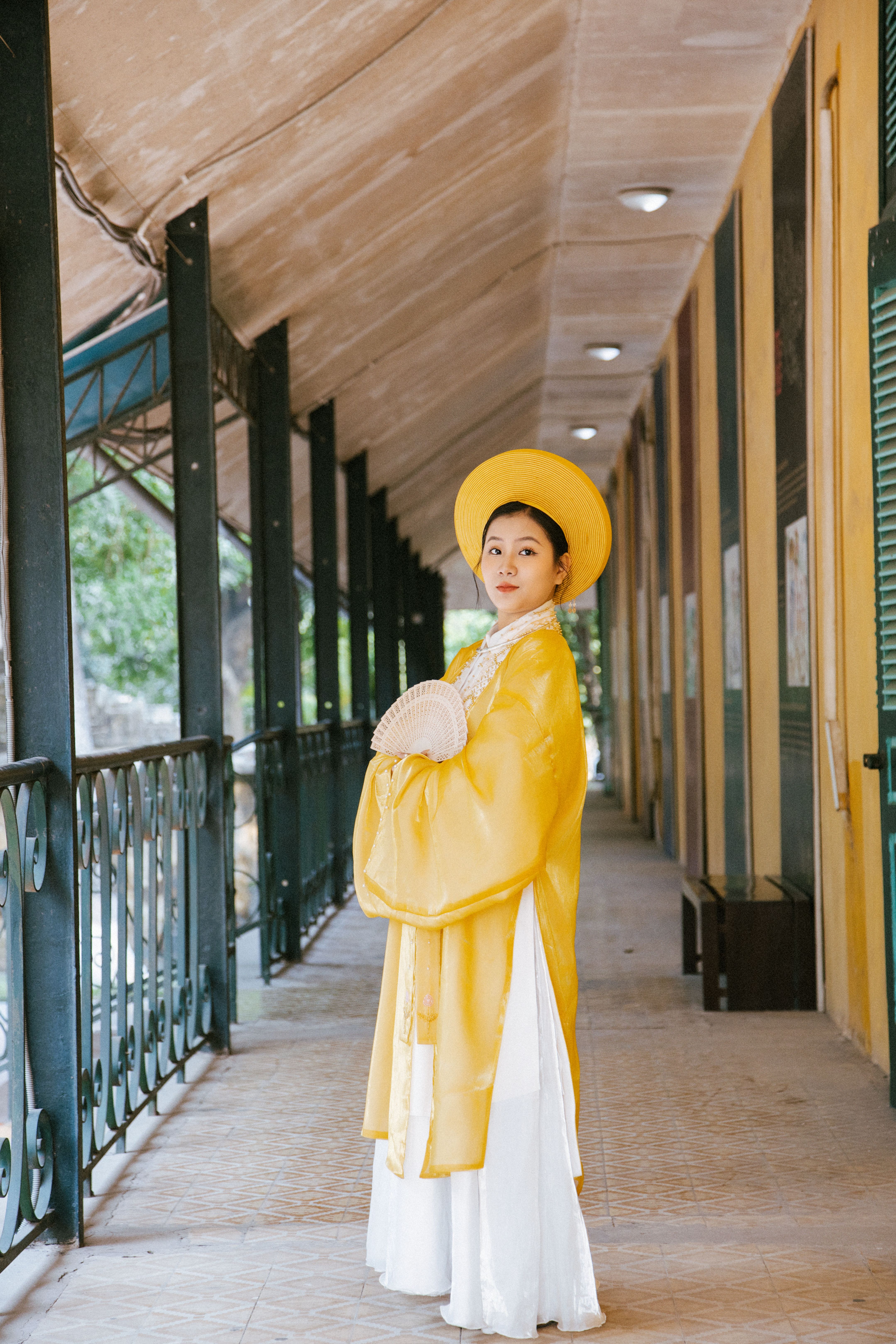 Woman in traditional Vietnamese áo dài in historical Hà Nội corridor.