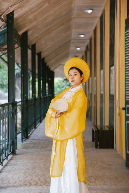 Elegant woman in traditional Vietnamese costume in Hanoi corridor, capturing cultural essence.