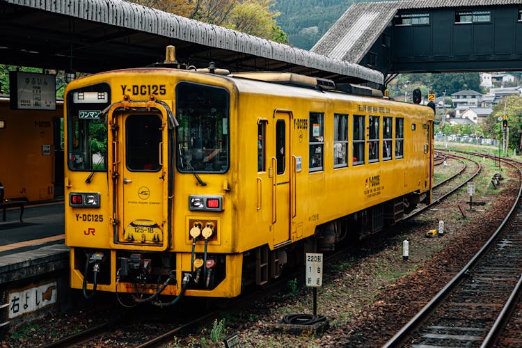 Old Yellow Train On Railway Near Station In Town