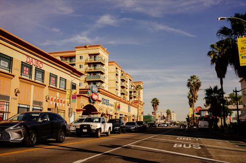 Free Vibrant city street scene showcasing traffic and popular stores on a sunny day. Stock Photo